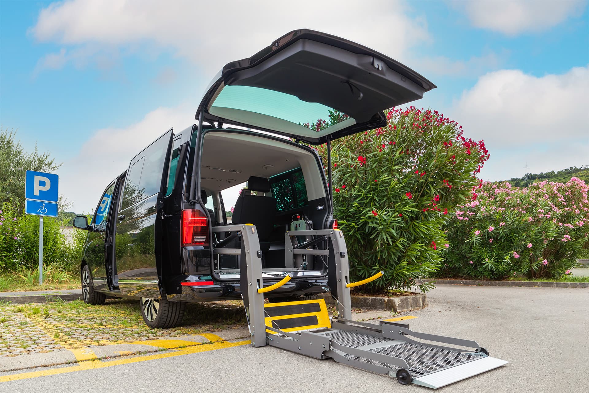 Wheelchair-accessible transport van with the rear ramp deployed in an accessible parking space